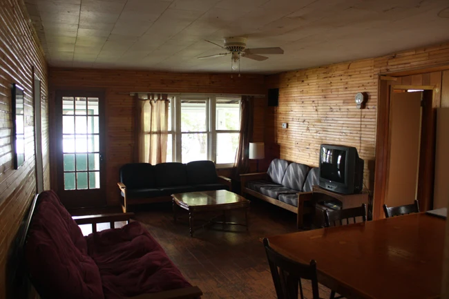 Pigeon Lake Resort Cottage two.&nbsp; Living room with sofas, coffee table, television, and wooden interior walls.